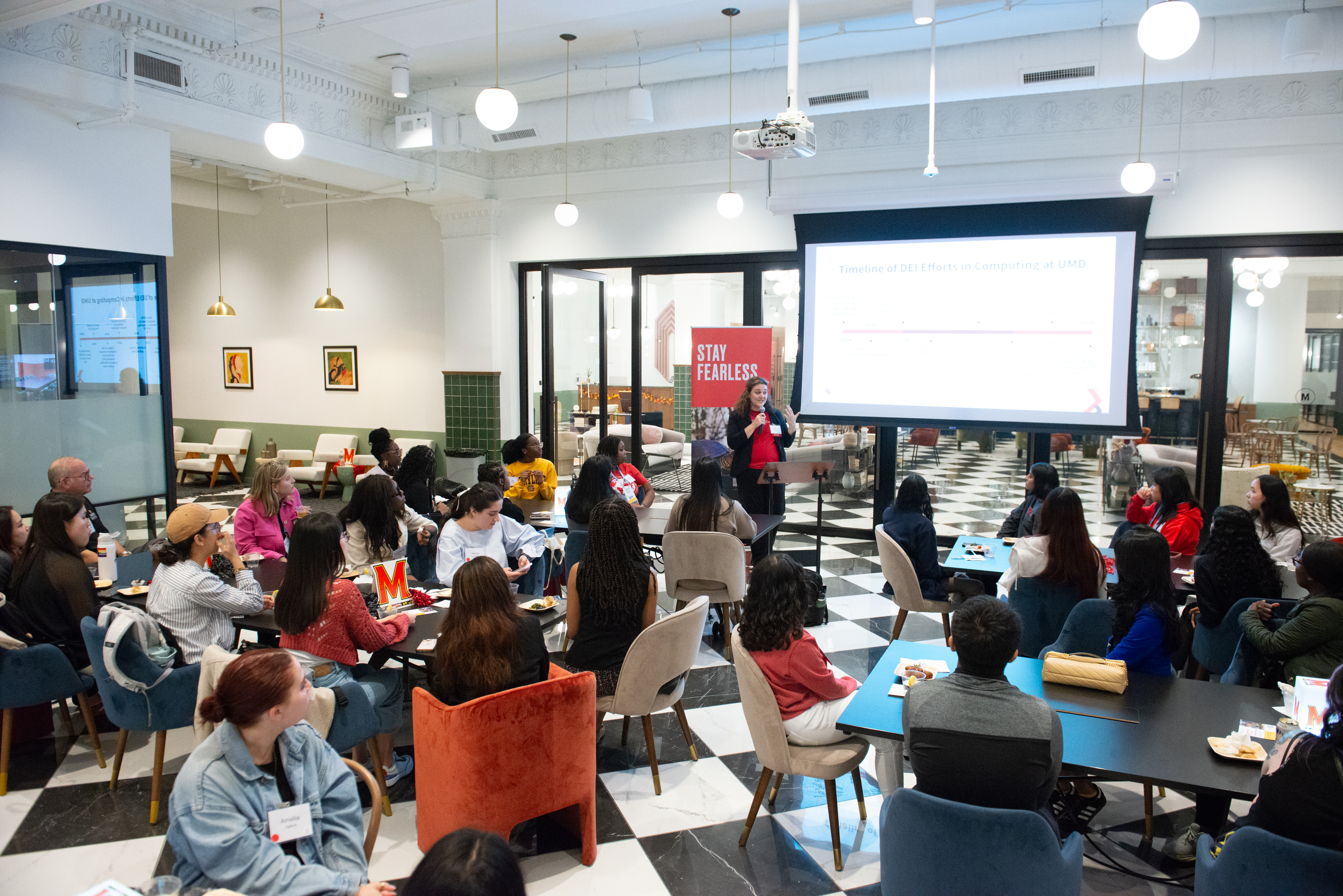 Kate Atchison speaking in front of a room of people at the Terps in Tech alum event at the Grace Hopper Celebration