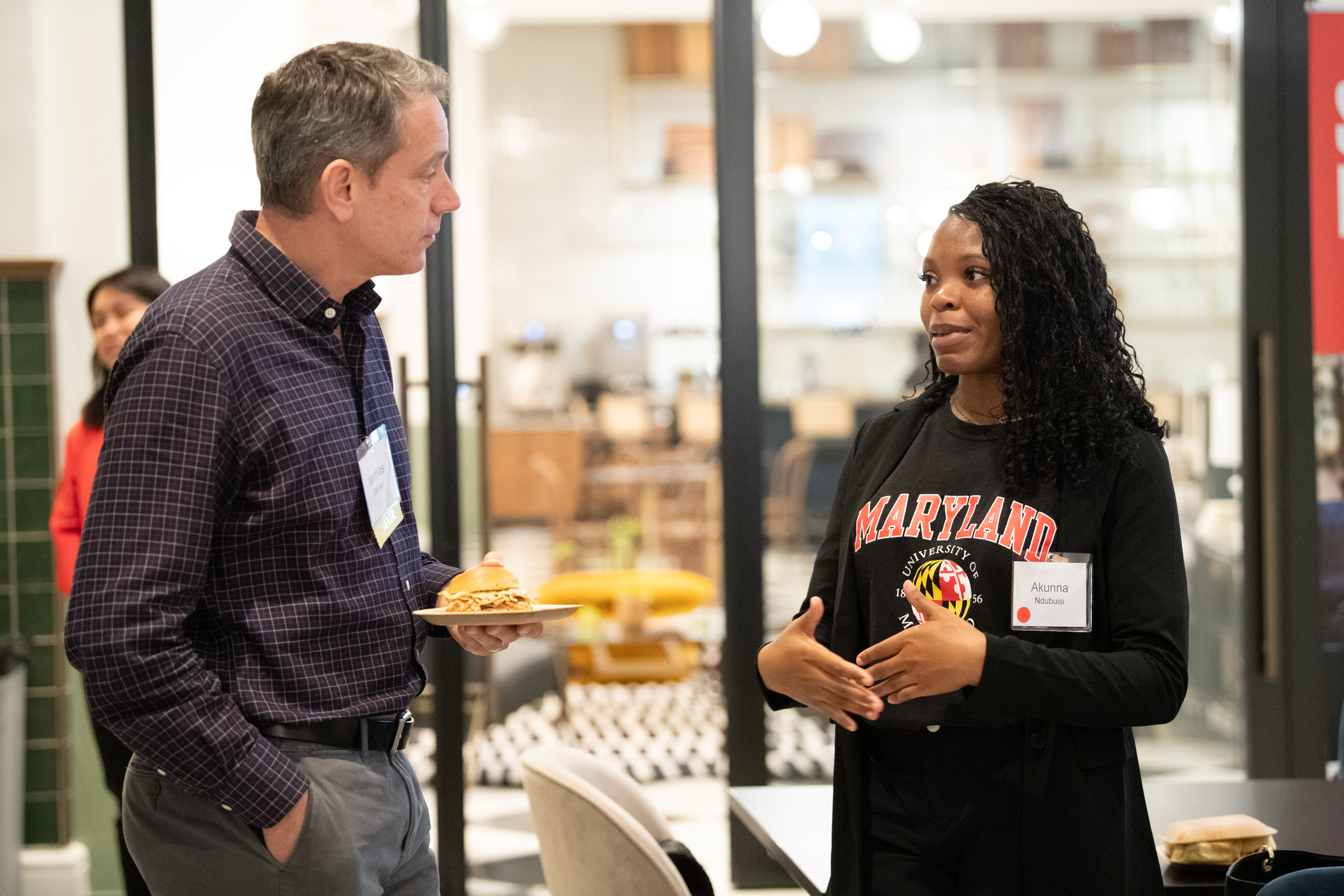 Computer Science Department Chair Matthias Zwicker speaking with a student at the Terps in Tech alum event at the Grace Hopper Celebration